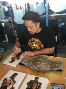 Goto signing w/Intercontinental Championship beside him